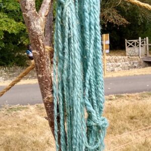 Blue yarn created from woad hanging on a stick