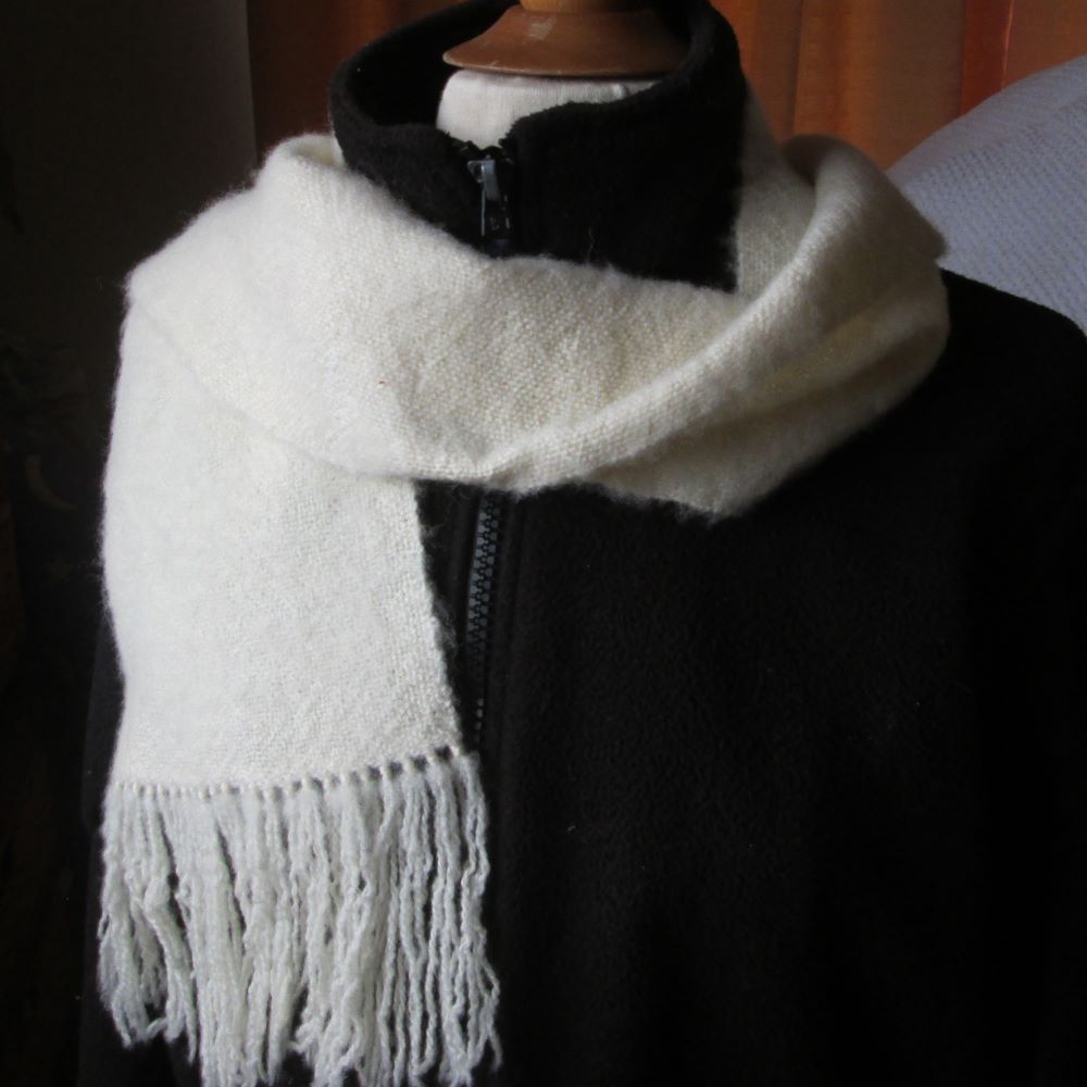 brushed cream scarf on a black jacket