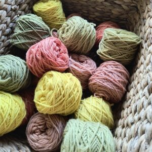 Yellow, green and red balls of yarn in a basket